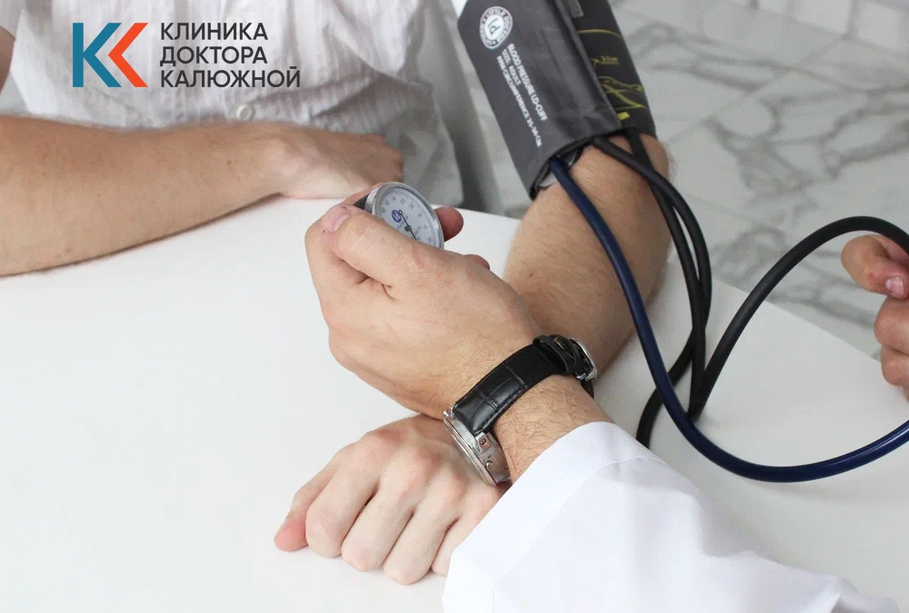 Врач-токсиколог измеряет давление пациенту в кабинете клиники